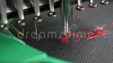 一种自动机器刺绣图案，黑色布上有红色的线。 机器人缝纫机。 自动缝纫机